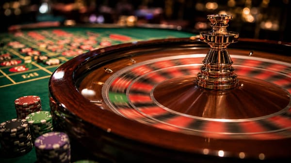 Fast-spinning European single-zero roulette wheel with a blurred green zero pocket and casino chips on the table.
